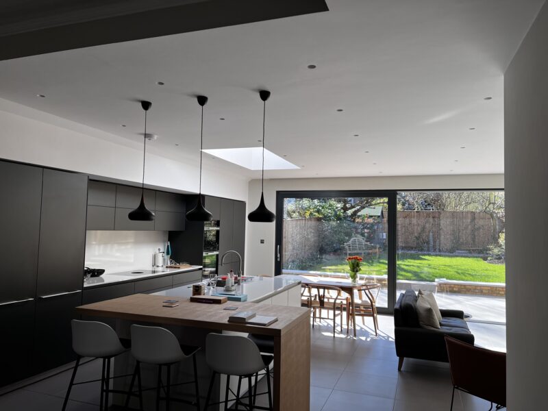 Open-plan kitchen with island, pendant lights and rooflight opening onto the garden