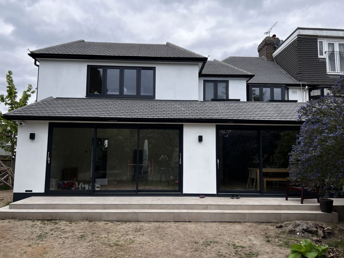 White single-storey rear extension with anthracite sliding doors on a semi-detached house in Kingston
