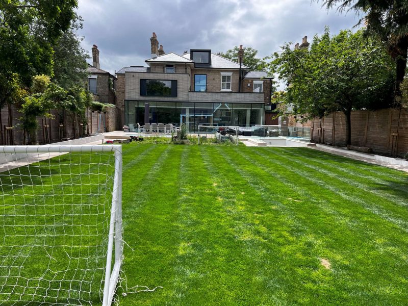 Rear of the Upper Richmond Road house with full-width glazing seen across the lawn