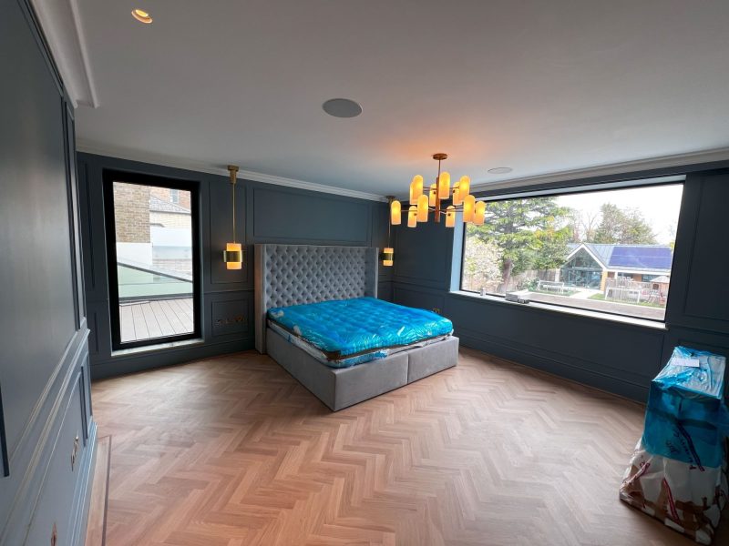 Panelled bedroom with herringbone oak floor and large window