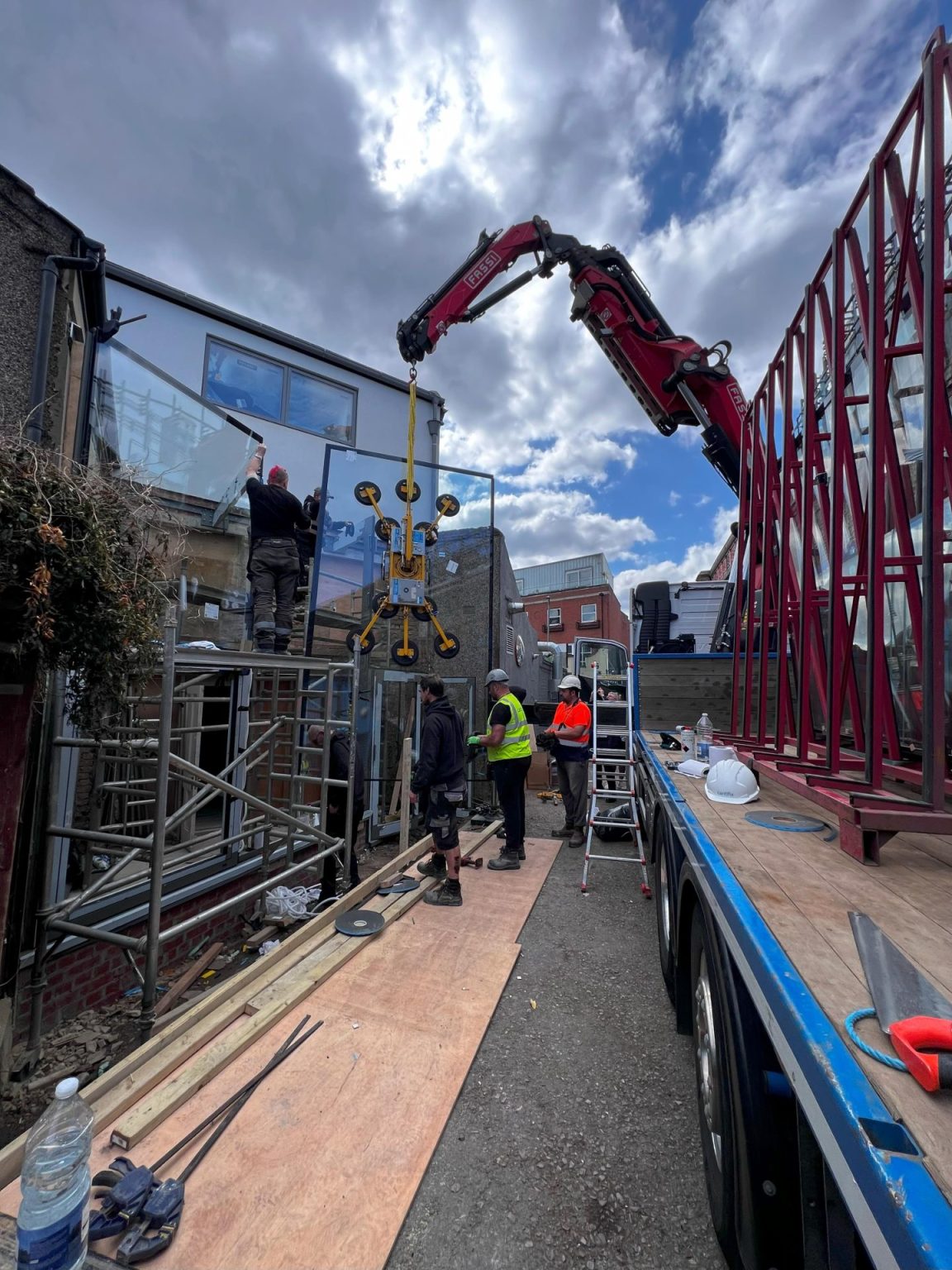 Large glazing units being lifted into place by crane on a Prohaus site
