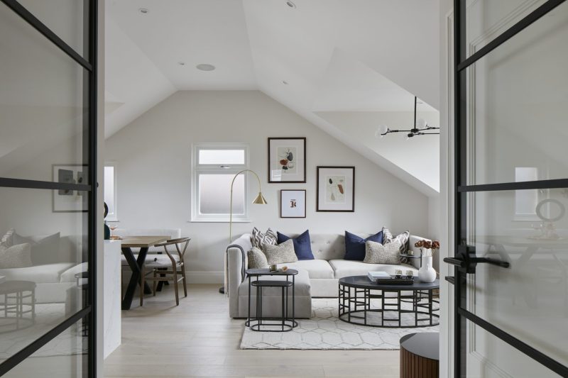 Living room with vaulted ceiling and black-framed glazed doors