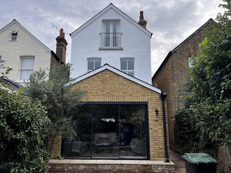 Brick rear extension with pitched roof and sliding glass doors in Kingston
