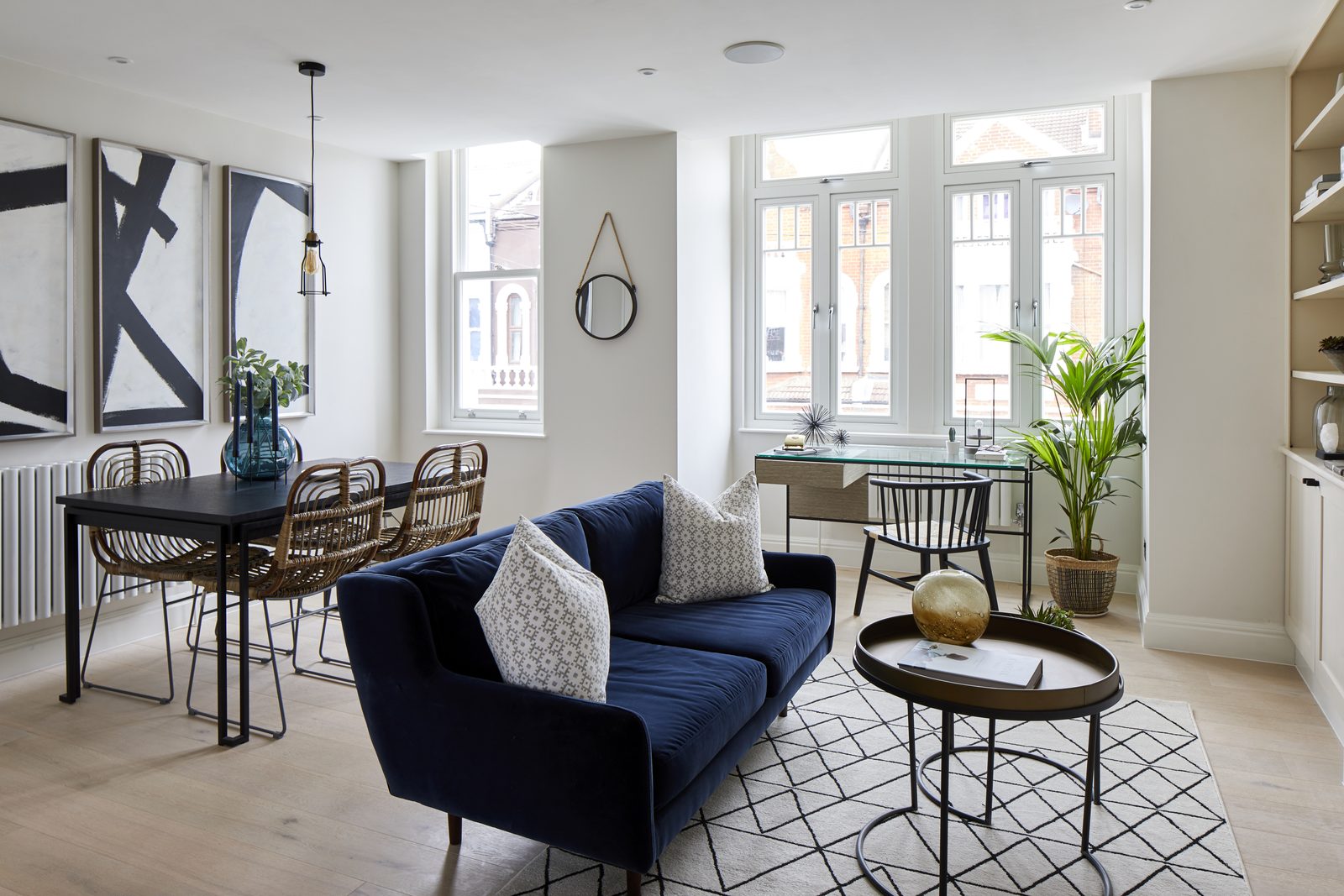 Refurbished open-plan living and dining room with tall windows and fitted shelving on Mysore Road, Clapham