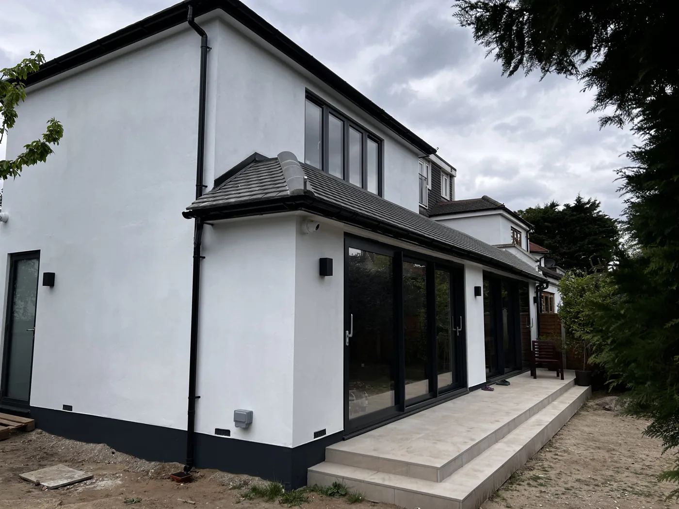 Side view of a single-storey extension with sliding doors and stone steps, Barnfield Avenue, Kingston