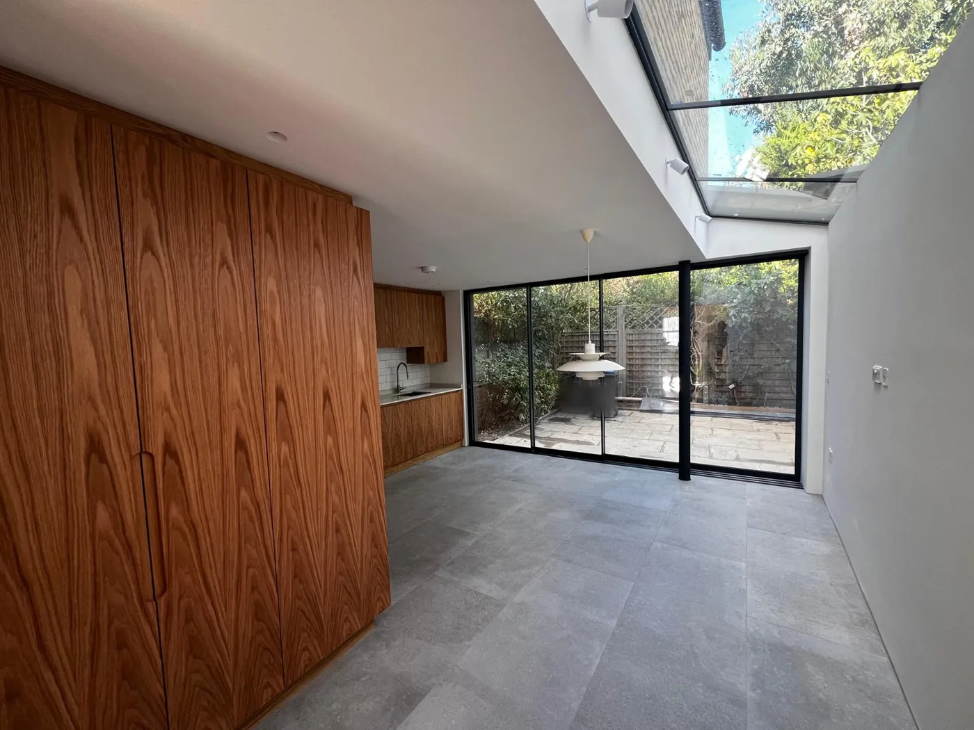 Kitchen extension with a glazed roof strip along the side wall and floor-to-ceiling timber units, Denmark Road, Wimbledon