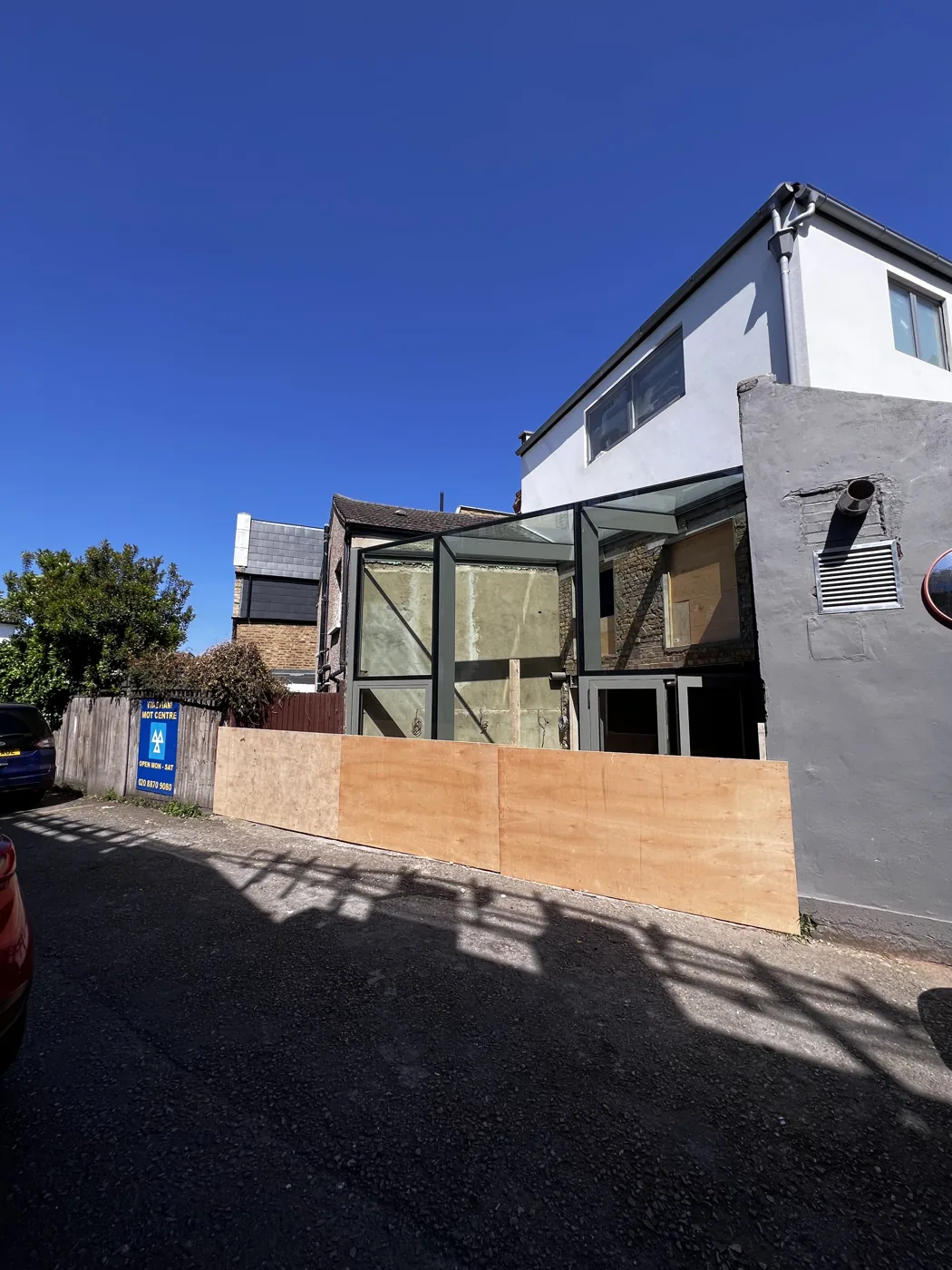House exterior during building work, with new glazing and site hoarding, Florian Road, Putney