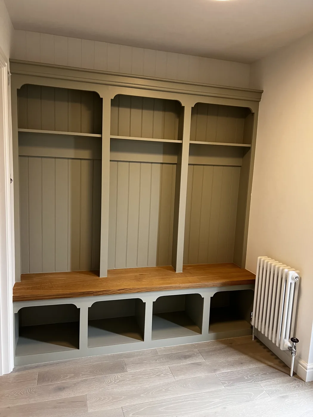 Painted bespoke bench seat with an oak top, cubbies and shelving