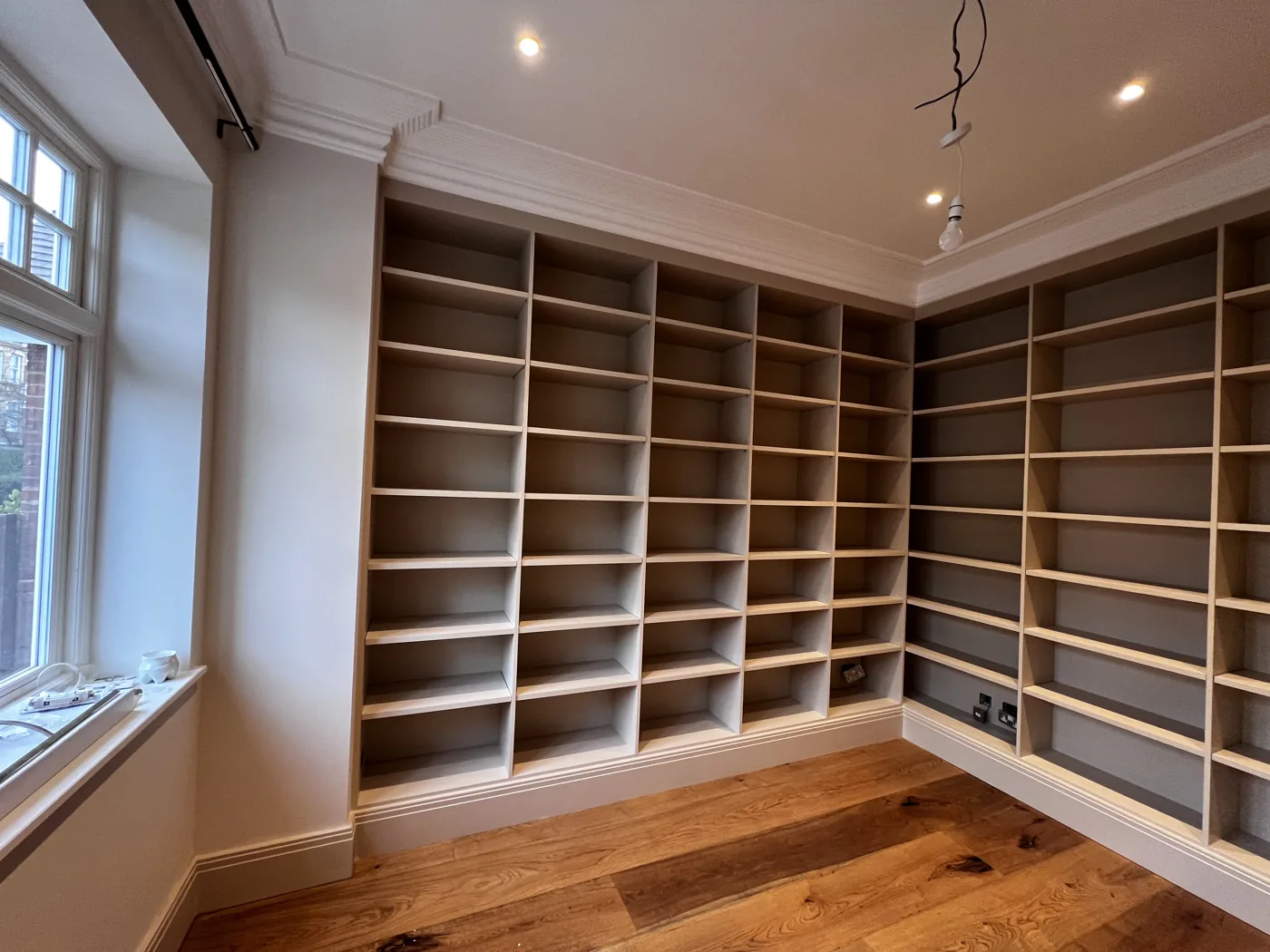 Floor-to-ceiling bespoke shelving wrapping the corner of a room