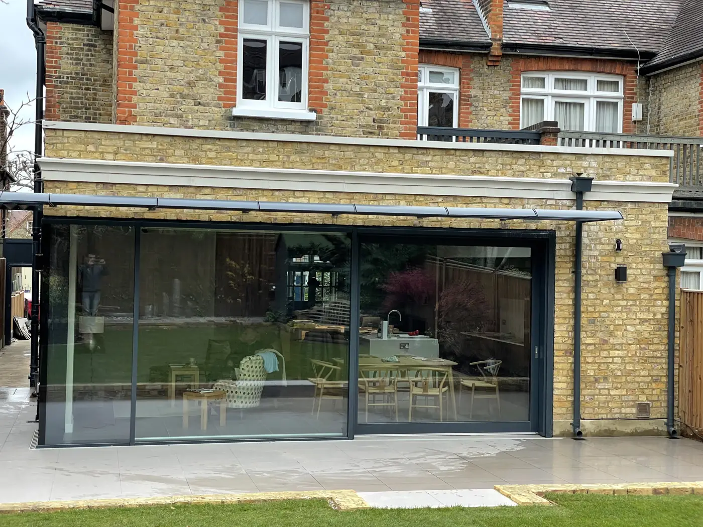 Slim-framed aluminium sliding doors across a rear extension, Montolieu Gardens, Putney
