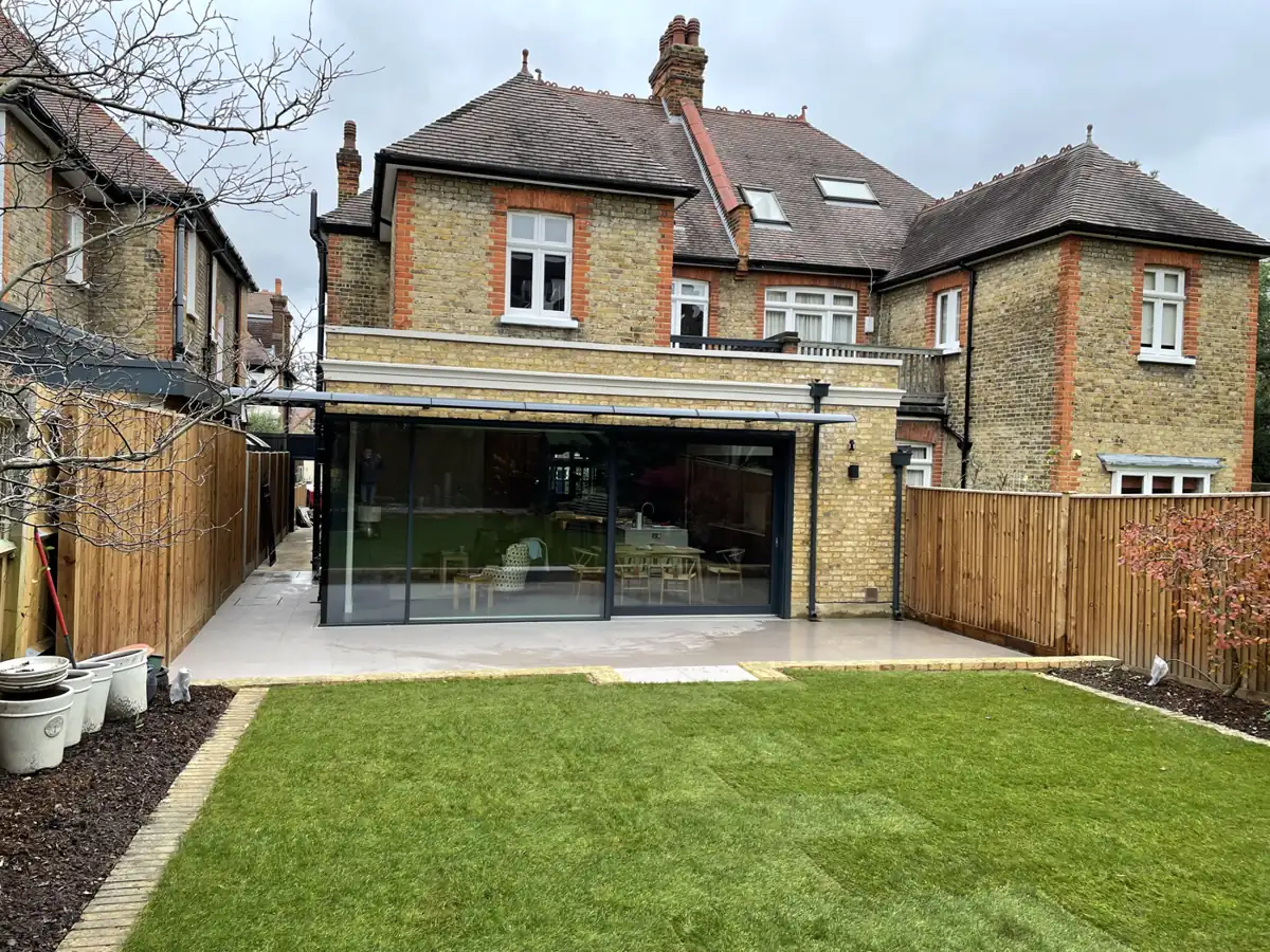 Single-storey rear extension with slim sliding doors and a new lawn, Montolieu Gardens, Putney