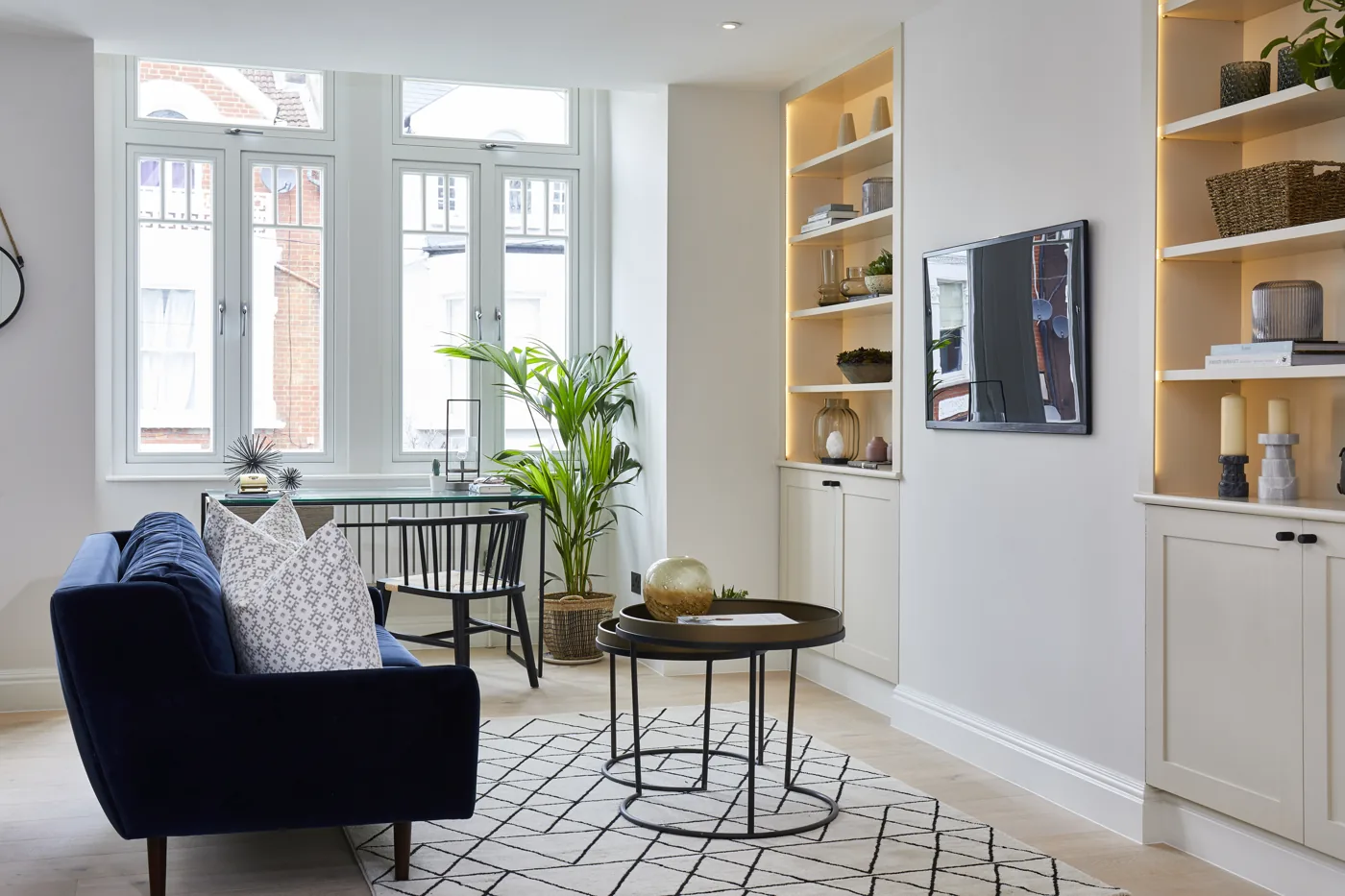 Living room with tall windows and built-in lit shelving, Mysore Road, Clapham